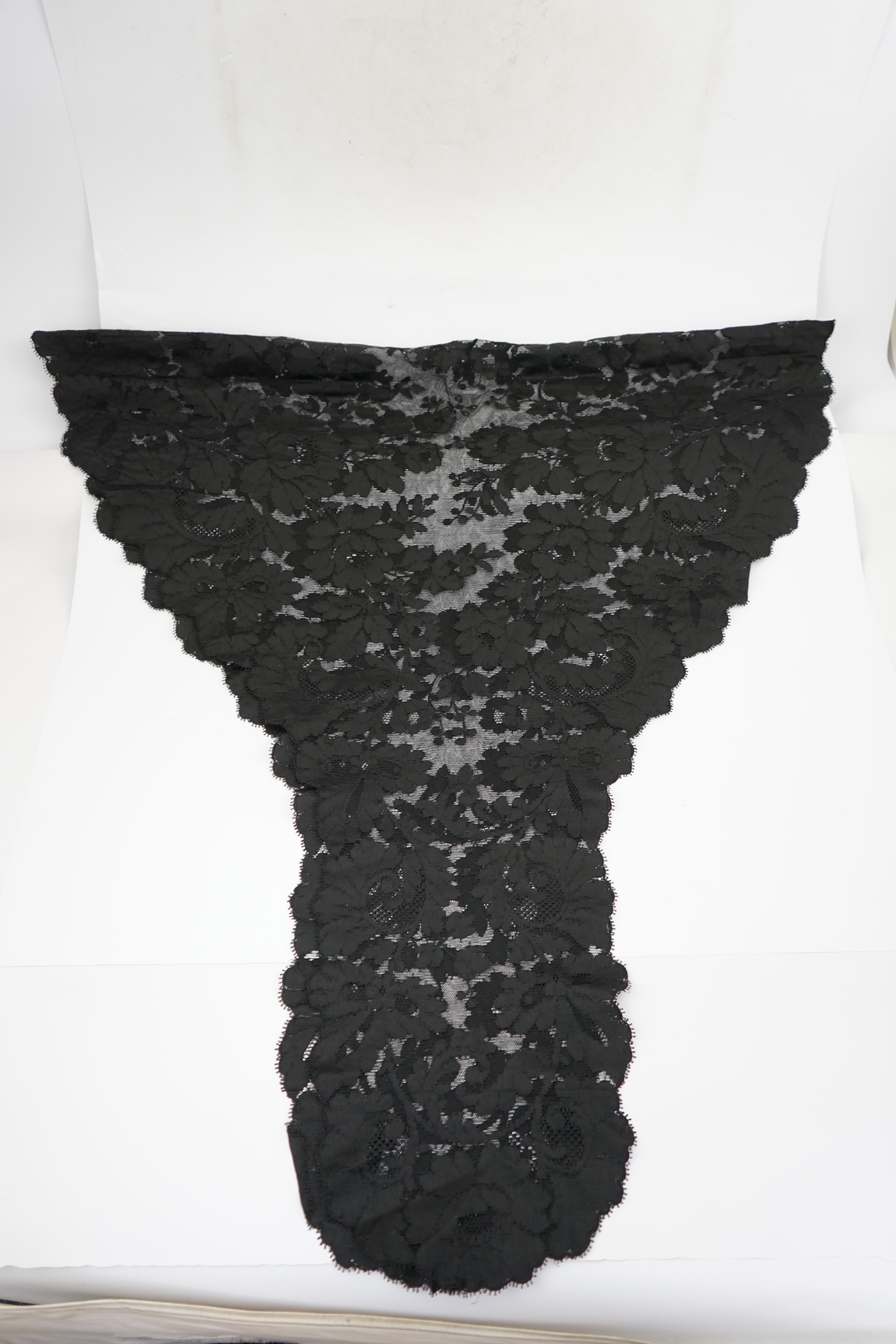 An 1930's black sequin cape, trimmings and lace, an Art Deco black sequin decorated cape on black net, an Edwardian jet beaded belt, a Spanish silk fall cap, three panels of black machine lace, a long length black and cr